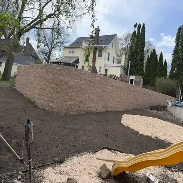 Completed retaining wall with graded landscaping
